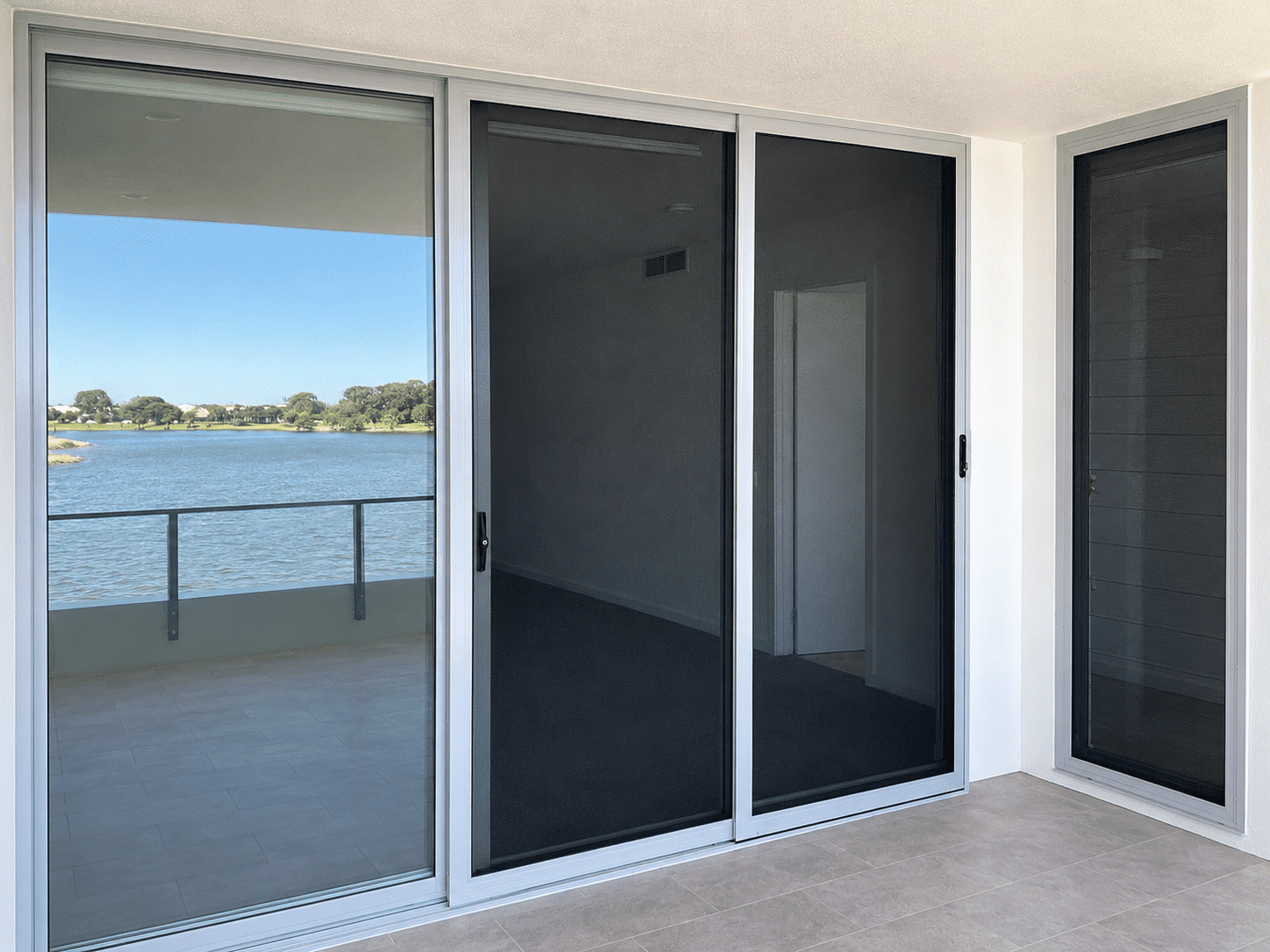 SecureView Saltwater Series security screens installed on sliding doors at a canal-front home.